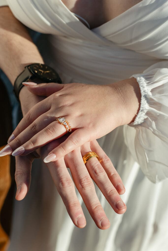 Close up detail of bride’s engagement ring and wedding band during their Crested Butte elopement, highlighting elegant gold bands and timeless jewelry styling.