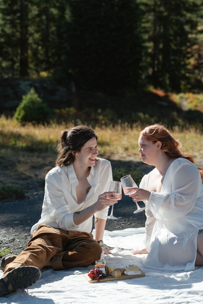 Couple enjoying champagne picnic during their Crested Butte elopement, featuring candid elopement photography, mountain picnic inspiration, and romantic Colorado wedding details.