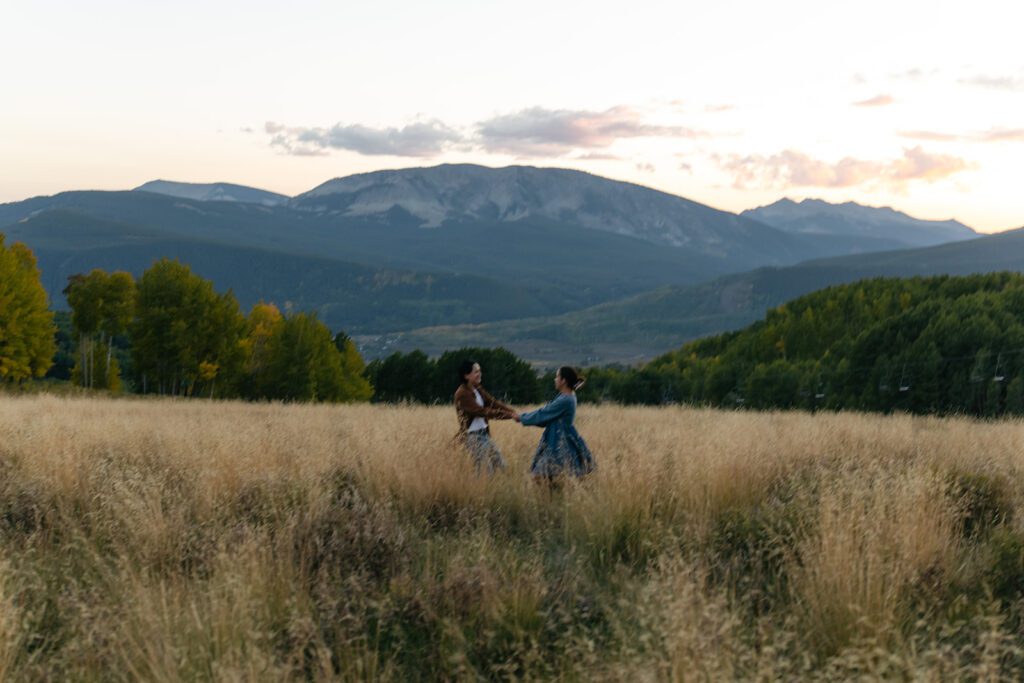 a couples spins in a dry grass field in Crested Butte in September