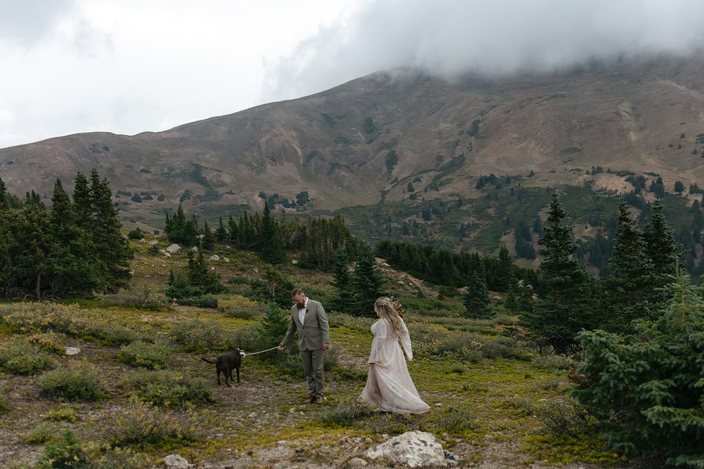 a couple and their dog explore the alpine terrain at Loveland Pass after having said their vows
